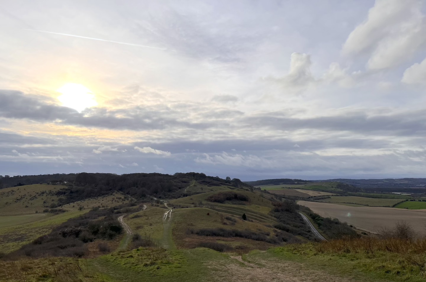 Looking south from Ivinghoe Beacon on New Year's Eve 2024, chalk path over a ridge to trees on the horizon